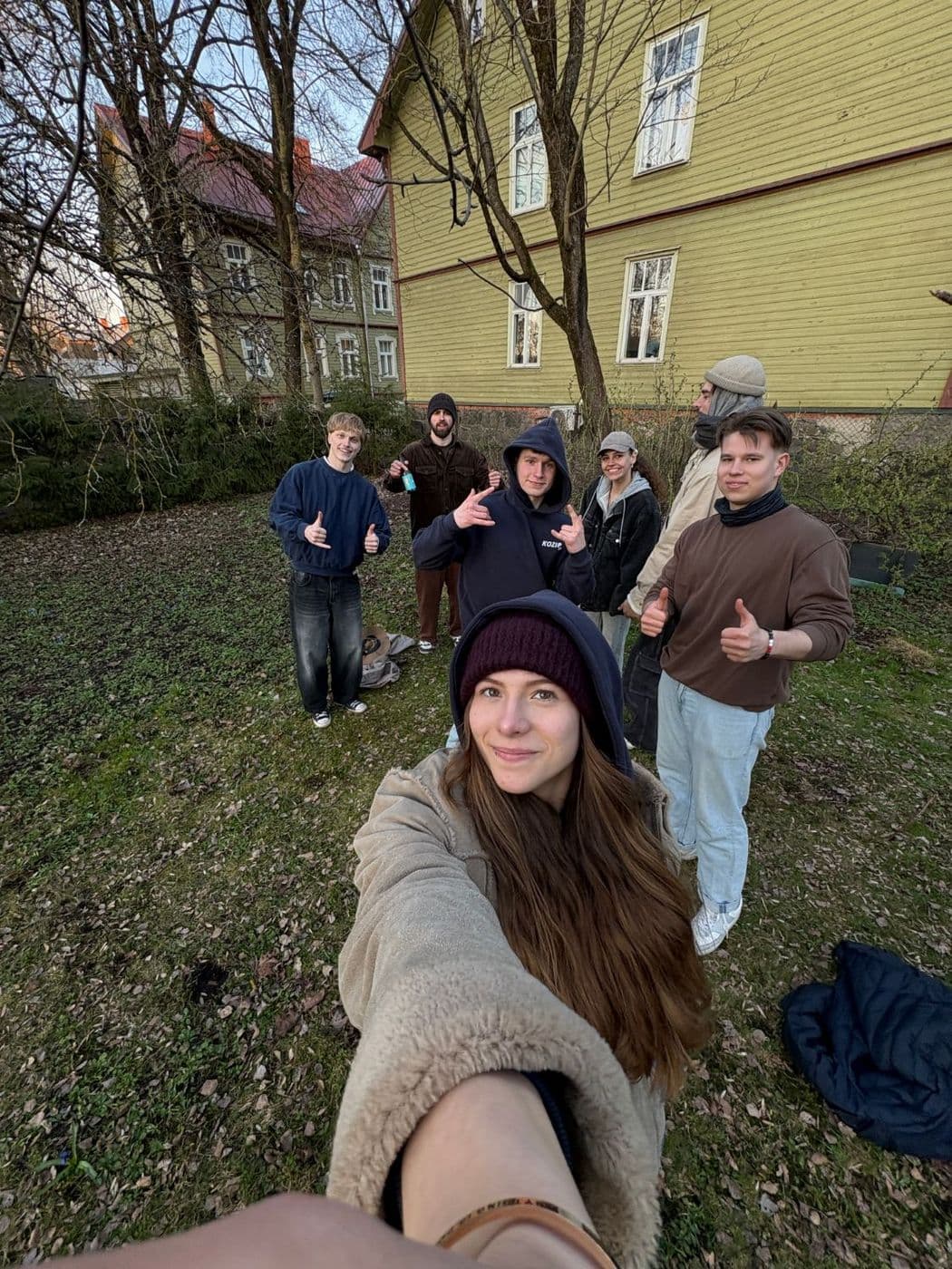 Seltskond sõpru õues puumaja ees